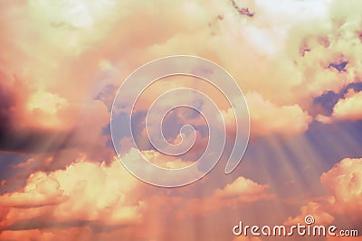 Rays of light make their way through the dark clouds. Vivid abstract natural background. Orange sky Stock Photo