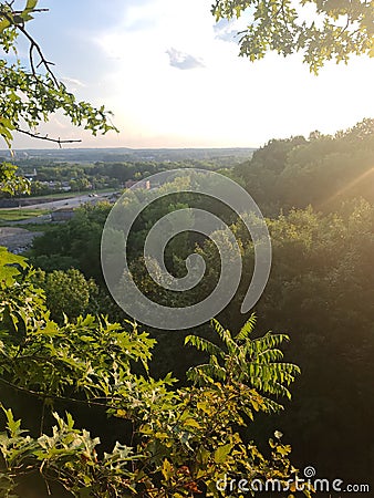 Rays tree tops sun set cliff Stock Photo