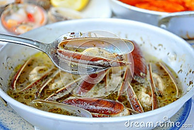 Razor clams cooked in white sauce (Saganaki) Stock Photo