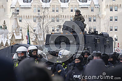 RCMP officer sits atop an armored vehicle as police drive Freedom Convoy protestors away from Parliament Hill in Ottawa Editorial Stock Photo