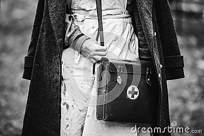 Re-enactor Wears Historical German Nurse Paramedic Of World War II Uniform With First Aid Kit. Photo In Black And White Stock Photo