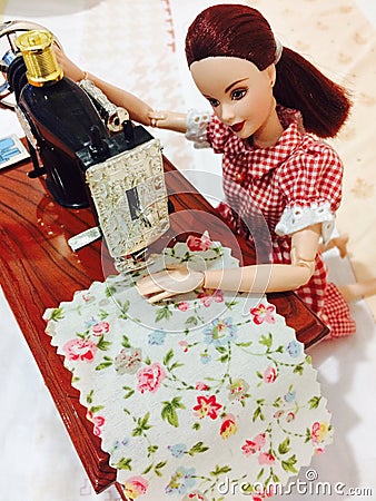 A beautiful barbie doll is sewing her clothes. Editorial Stock Photo