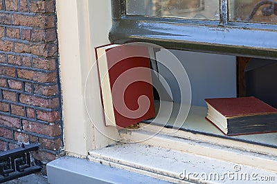 Re use an old book to keep the window open close up Stock Photo