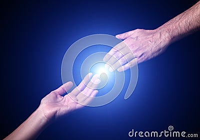 Reaching and touching hands. Bright light star flare with touching fingertips. Stock Photo