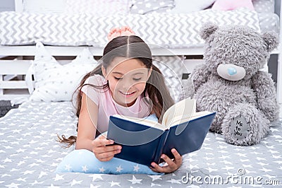 Read fairytale in bed. Girl child lay bed with teddy bear read book. Kid prepare to go to bed. Time for evening Stock Photo