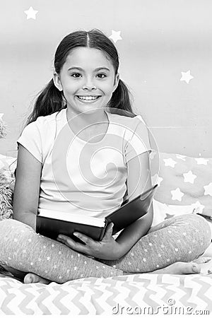 Read fairytale before go to bed. Girl child sit bed with teddy bear read book. Kid prepare to go to bed. Pleasant time Stock Photo
