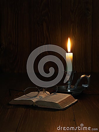 Reading by candlelight Stock Photo