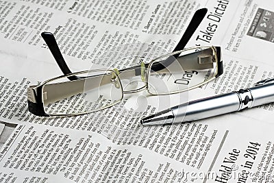 Reading Glasses on the Newspaper with Pen Editorial Stock Photo