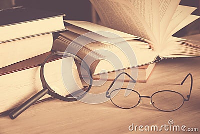 Reading glasses and magnifying glass with olds book on table Stock Photo