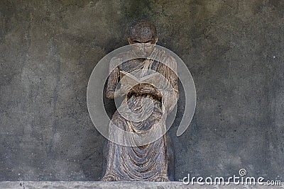 A reading monk statue with day light Stock Photo