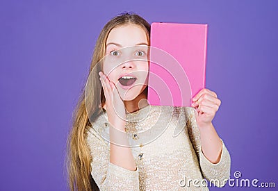 Reading skill. Personal diary. Textbook presentation. Study and learn. Girl hold book violet background. Kid show book Stock Photo