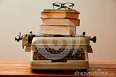 Reading, storytelling and education. Concept for writing, writer and fiction. A typewriter and a stack of books. Stock Photo