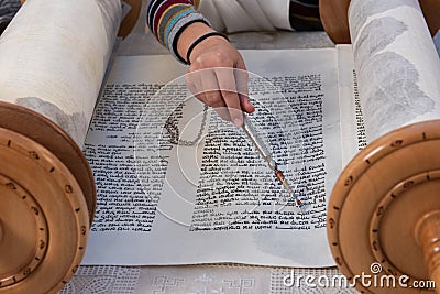 Reading the Torah scroll with a silver yad or pointer Stock Photo