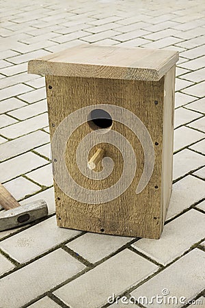 Ready birdhouse on stone floor. Help birds in spring Stock Photo