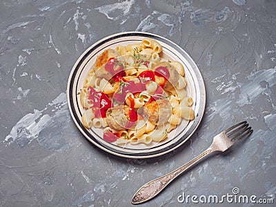 Ready breakfast of pasta with turkey meatballs on a light plate with black stripes and ketchup, shot close-up, near the dining Stock Photo