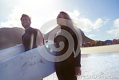 Ready for an epic surfing session. an athletic young couple surfing at their favourite beach. Stock Photo
