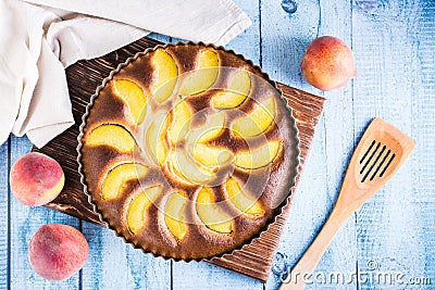 Ready fresh peach pie in a baking dish on the table. Homemade dessert. Top view Stock Photo