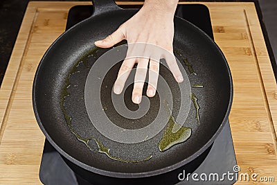 Ready for frying on the pan concept represented by hand cheking temperature. Stock Photo