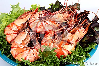 Grilled large fresh prawns served with megetables on blue plate Stock Photo