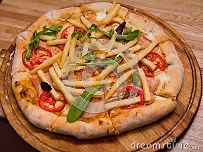 Ready pizza on a wooden plate. Stock Photo