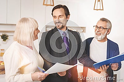 Cheerful insurance agent working with retired couple Stock Photo
