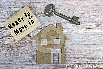 Ready to move in text on wooden keychain with house model and key on wooden desk Stock Photo