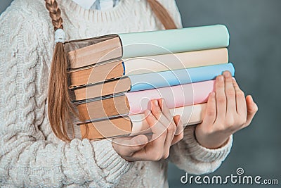 Ready to study hard Strong smart girl is holding books and is isolated on grey background. Stock Photo