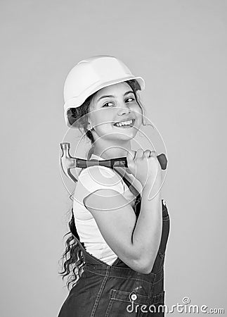 ready to work. building and repair tools. repairman. small girl repairing in workshop. cheerful kid in helmet hold Stock Photo