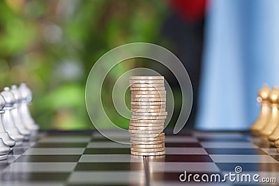 Ready two pieces of chess pieces on a chess board and a stack of euro coins in the middle Stock Photo