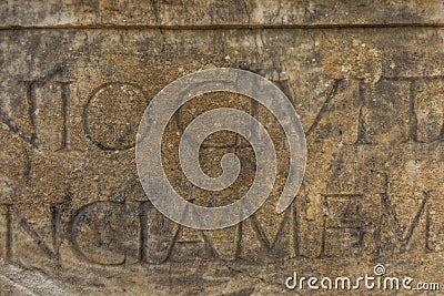 Real ancient letters cutted in stony wall of ancient architecture Stock Photo