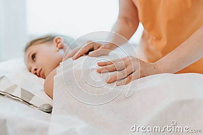 Real doctor osteopath hands does physiological and emotional therapy for eight year old kid girl. pediatric osteopathy treatment s Stock Photo