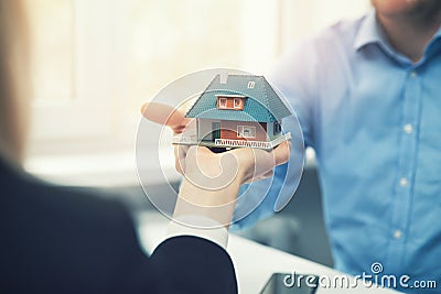 Real estate agent architect presenting house model to customer Stock Photo