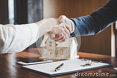 Real estate agent and customers shaking hands together celebrating finished contract after about home insurance and investment lo Stock Photo