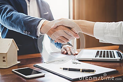 Real estate agent and customers shaking hands together celebrating finished contract after about home insurance and investment lo Stock Photo