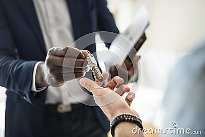 Real estate agent handing the house key to a client Stock Photo