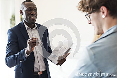 Real estate agent handing the house key to clients Stock Photo