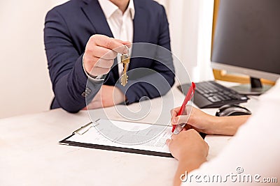 Real estate agent holding house key to his client after signing contract,concept for real estate, moving home or renting property Stock Photo