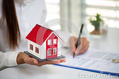 Real estate agent with house model.Real estate agent offer house represented by model Stock Photo