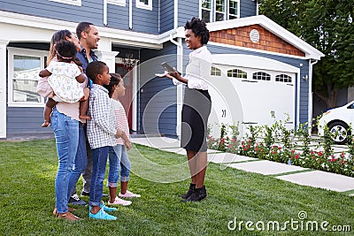 Real estate agent showing a family a house Stock Photo