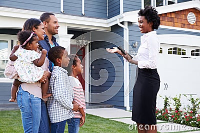 Real estate agent showing a family a house, closer in Stock Photo