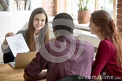 Real estate agent showing house plan to multiethnic married coup Stock Photo