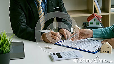 Real estate agents talk to customers on leases. Or buy a home with home loan offers and home insurance with rent. Stock Photo