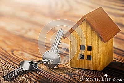 Real estate concept with small toy wooden house and key on wooden background. Idea for real estate concept, personal property an Stock Photo