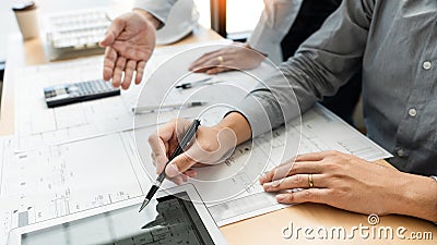 Real-estate concept, Two engineer and architect discussing blueprints data working and digital tablet on construction building Stock Photo