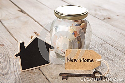 Real estate finance concept - money glass with New Home word Stock Photo