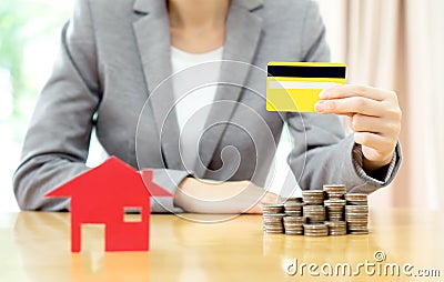 Real estate investment by credit card. House and coins on table. Stock Photo