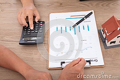 Real estate salespeople use calculators to calculate prices for home buyers Stock Photo