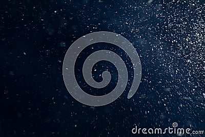 Real falling snow in slow motion while driving on a dark blue background. Snow texture for design in graphic editors Stock Photo