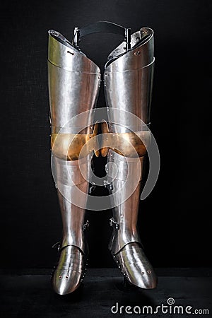 Real knight armor for legs on a black Stock Photo