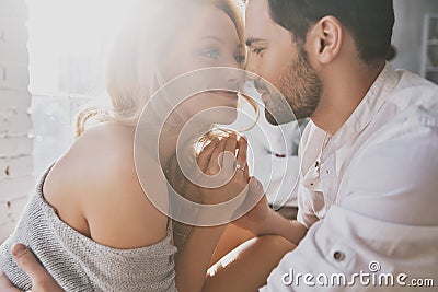Real love. Beautiful young couple bonding and smiling while sitting in the bedroom Stock Photo